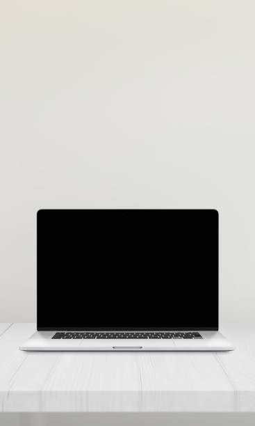 istock Laptop with a blank screen on a desk against a white wall, ideal for mockup presentations of websites 2187566513