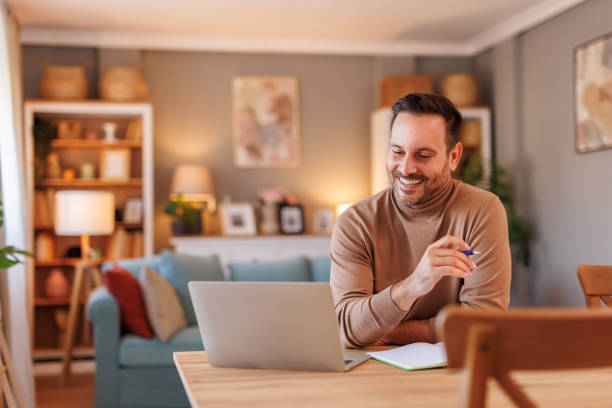 istock Portrait of happy male freelancer developing software over laptop while working at desk in home office 2187569890