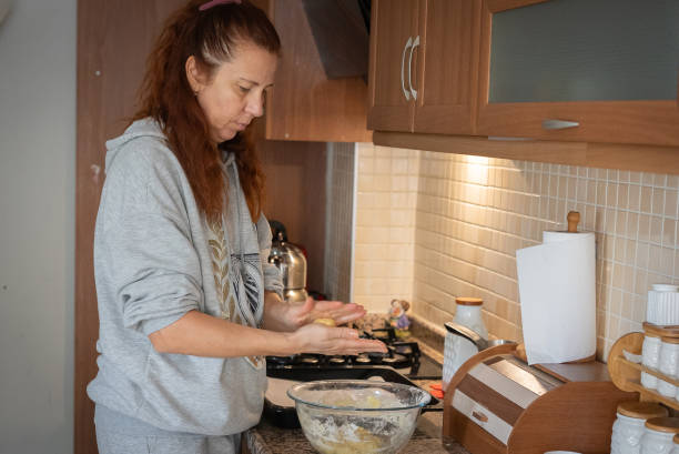 istock Mature woman preparing cookie balls in home kitchen 2187570212
