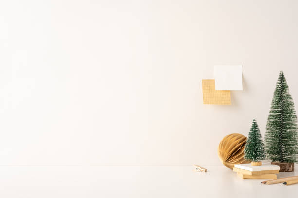 istock A side view minimalist Scandinavian-style workspace featuring small Christmas trees, books, and a neutral color palette. The setting exudes simplicity and a serene winter atmosphere 2187575572