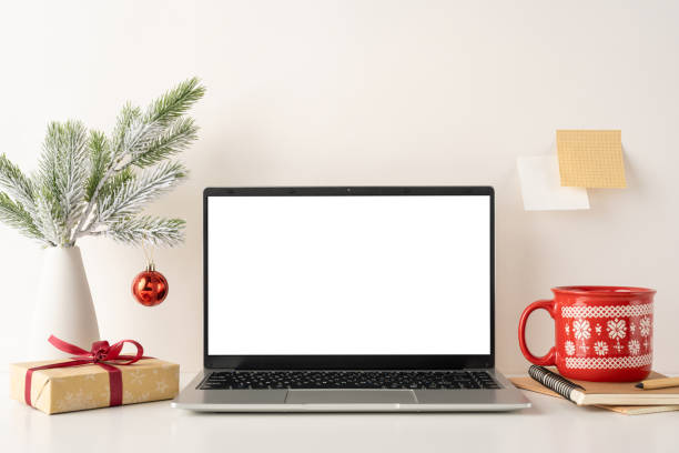 istock A still life cozy minimalist workspace with a laptop, festive decorations, and Scandinavian style. Features a red cup, gift box, and a small Christmas ornament creating a warm winter atmosphere 2187575582