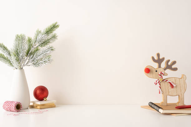 istock Minimalist side view Scandinavian workspace featuring a festive wooden reindeer ornament, pine branches, and a red bauble, creating a warm seasonal feel 2187575587
