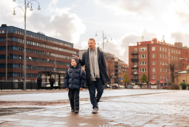 istock Father stroking son's head while walking in Scandinavian city 2187576431