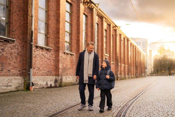 istock Father and son exploring brick building and walking on tramway in city 2187576452