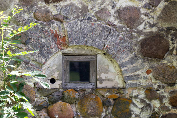 istock An old stone wall with a window in an arched bay 2187577889