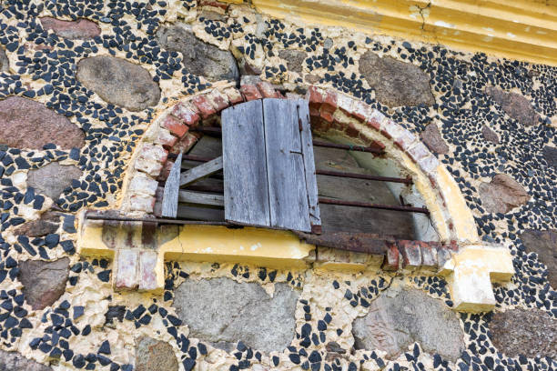 an old rusty window with a slot in the stone wall