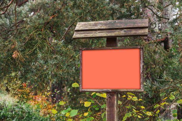 istock Empty red billboard in an autumn forest. Advertising frame ready for text. Marketing display set against a backdrop of fall foliage. 2187579784