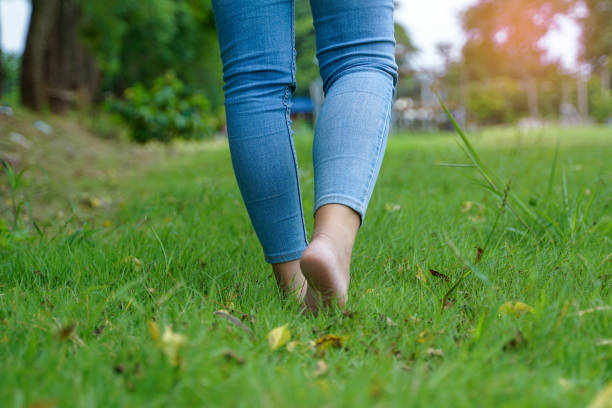 istock Asian woman walking barefoot on the grass 2187582991