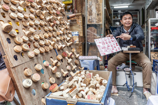 Hanoi, Vietnam - March 20, 2024: Vietnamese man making stamps on the Weekend Walking Street in Hanoi