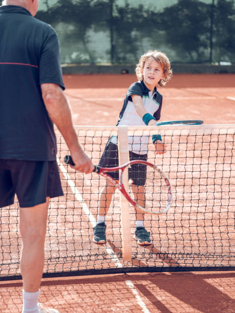 istock Active little boy practicing tennis with crop male instructor 2187584016
