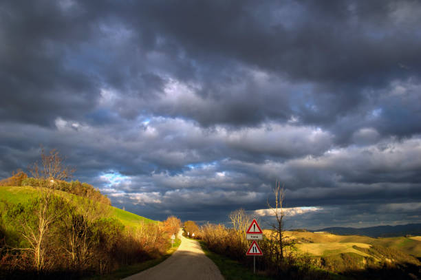 Montefeltro hilly landscape with fields in golden hour against cloudy sky