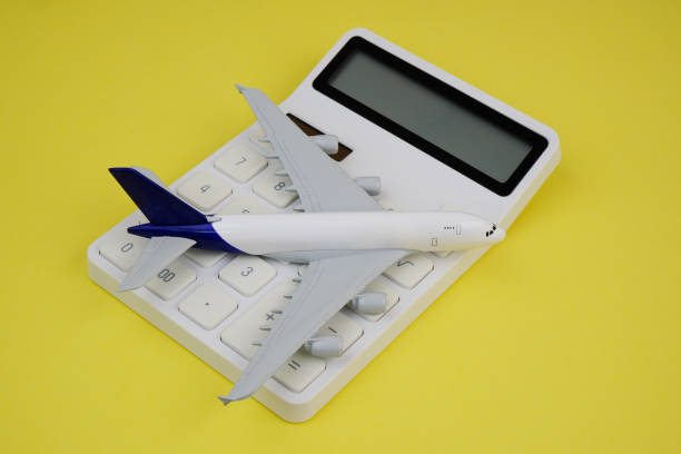 istock Airplane on white calculator on yellow background. 2187590058