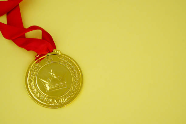 Gold medal with crown on yellow background. Copy space for text.