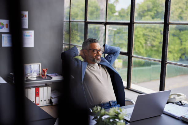 istock Mid adult businessman taking a break in his modern office 2187591990