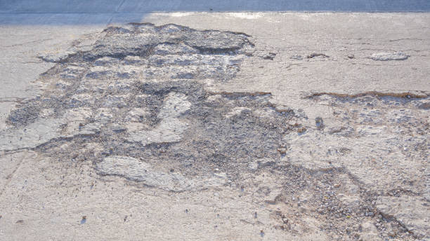 Cracks and broken texture with collapse of the old badly damaged concrete street surface
