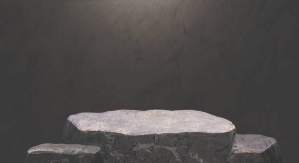 istock Rock stone podium on dark gray cement loft wall background in monochrome style with studio lighting on surface for product display presentation 2187592315