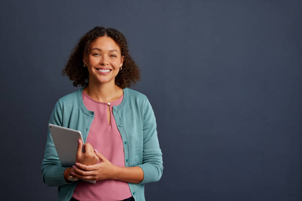 istock Smiling african american woman holding digital tablet 2187592525