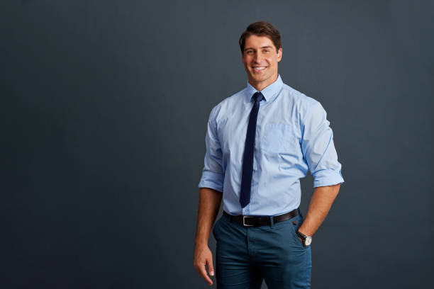 istock Confident business man smiling isolated on blue wall 2187592584