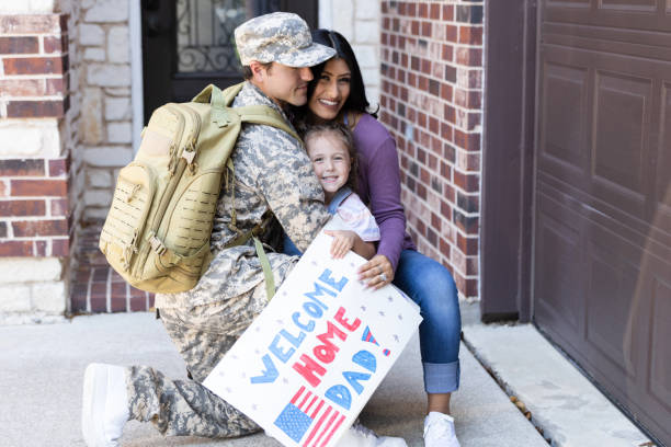 istock Proud wife smiles while embracing her military husband home from deployment 2187593427