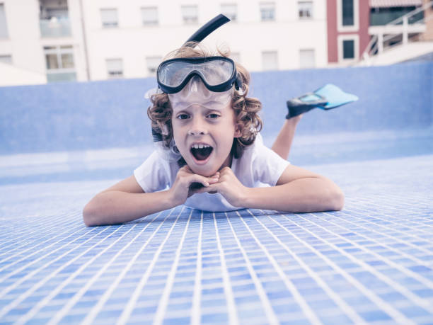 istock Amazed cute boy lying on bottom of empty pool 2187597965