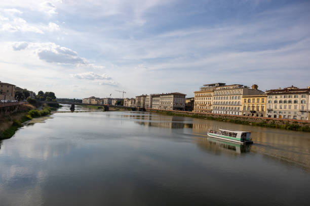 A blue river with a boat and city buildings surrounding both sides