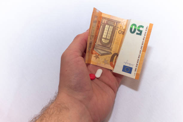 istock Hand holding euro banknotes and pills tablets medicals. 2187600621