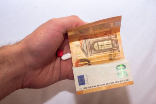 istock Hand holding euro banknotes and pills tablets medicals. 2187600631