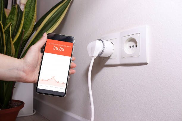 istock Smart plug with energy monitoring app displaying power consumption statistics. 2187604538
