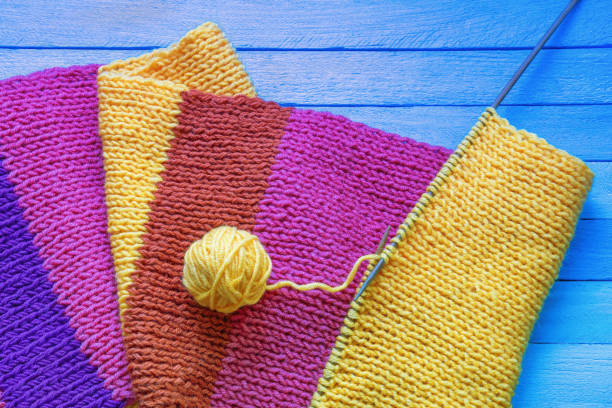 Close-up of bright multi-colored knitted wool fabric. Detailed textures and rich colors highlight the quality and appeal of this piece.