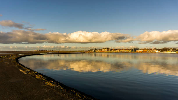 View across marine lake at West Kirby, Wirral, UK  People can be seen on the promenade