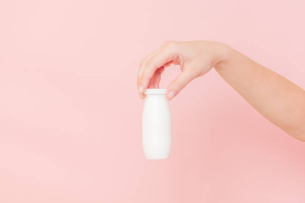 istock Hand holding bottle of probiotic yogurt for digestive system. Dietary supplements for stomach 2187614814