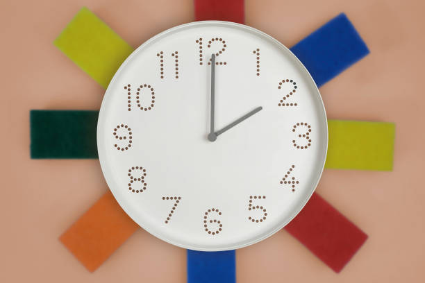 clock showing two o'clock on wall with cleaning sponges