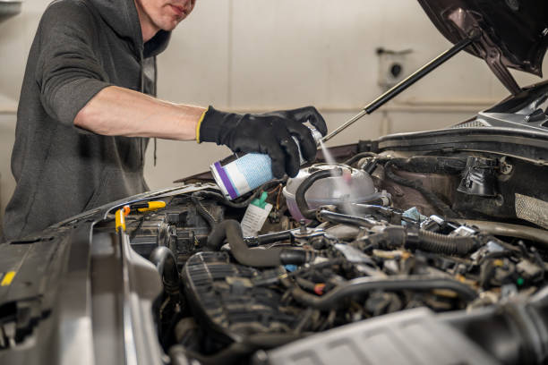 istock Mechanic wearing gloves sprays cleaner on a car engine  in a garage 2187617633
