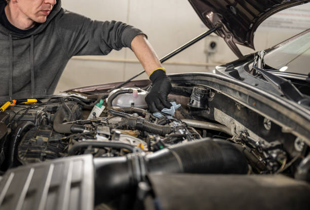 istock Mechanic performing engine maintenance on a car in a garage. 2187617635