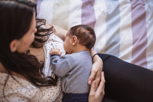 istock Breastfeeding Mother with Newborn Baby in Cozy Home Setting 2187626193