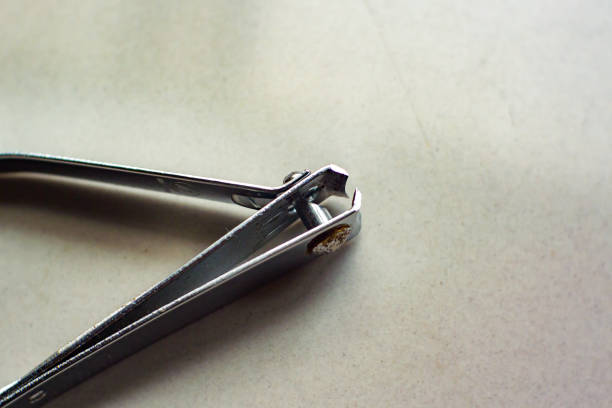 An Asian woman is trimming her fingernails carefully