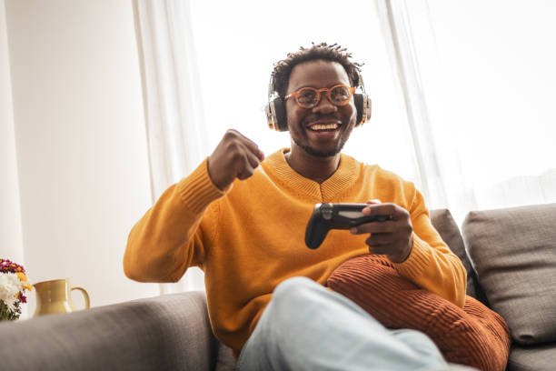 istock Joyful gamer enjoying video game on the sofa at home 2187642503