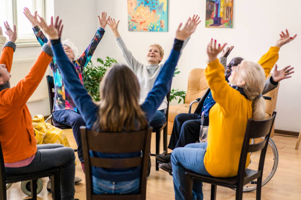 istock Diverse people laughing and raising their hands at group therapy 2187647530