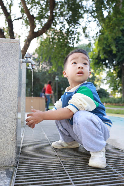 istock Little child washing hands and drinking water 2187649710