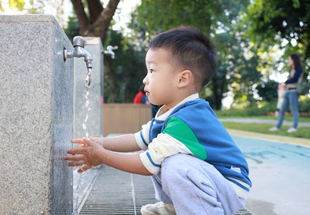 istock Little child washing hands and drinking water 2187649721