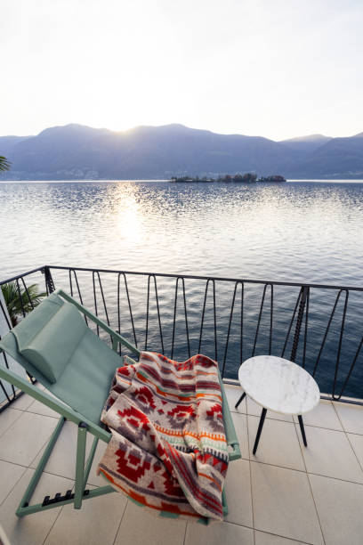 istock Serene Balcony View with Cozy Blanket and Lake at Sunset 2187650263