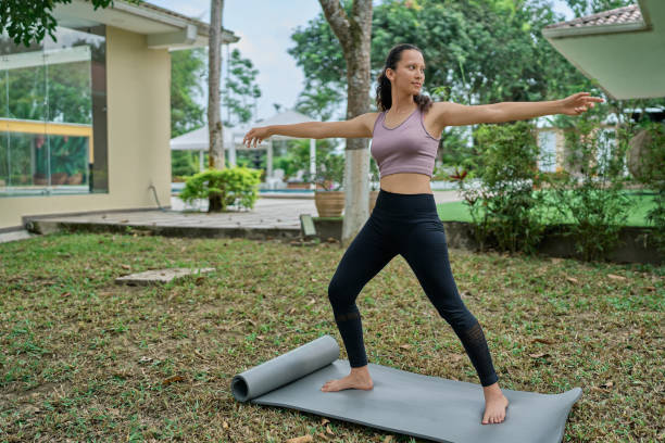istock Woman practicing warrior yoga pose outdoors 2187652858