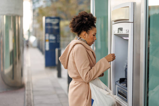 istock Woman using a street ATM machine in the city 2187659456