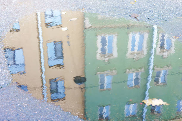 istock Reflection of a building in a puddle of water 2187660689