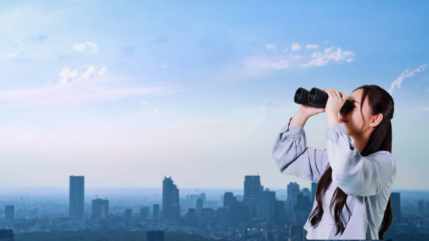 istock Young asian woman watching the city with binoculars. 2187662459