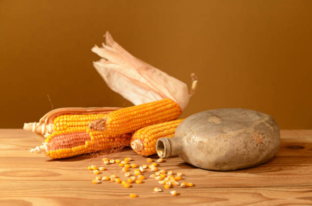 Still life, corn, aluminum flask in the studio on a wooden table