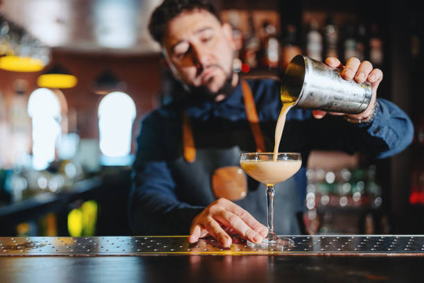 Bartender pouring a Daiquiri cocktail from the cocktail shaker stock photo