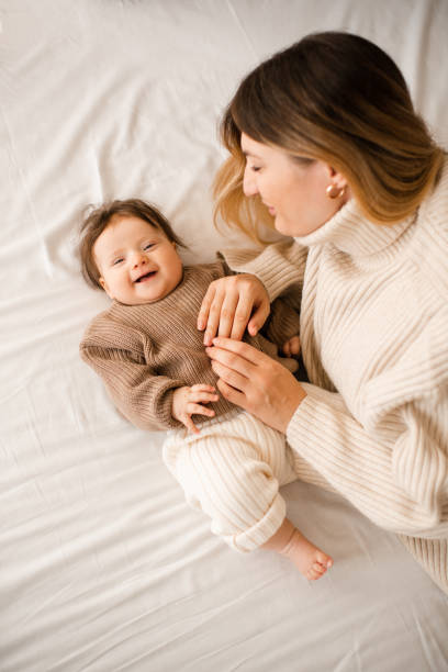 istock Baby girl lying in bed with mom 2187667789