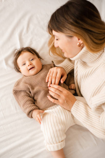 istock Baby girl lying in bed with mom 2187667793