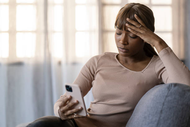 istock Pensive woman looking at smartphone, absorbed in thoughts during modern digital engagement. 2187671244